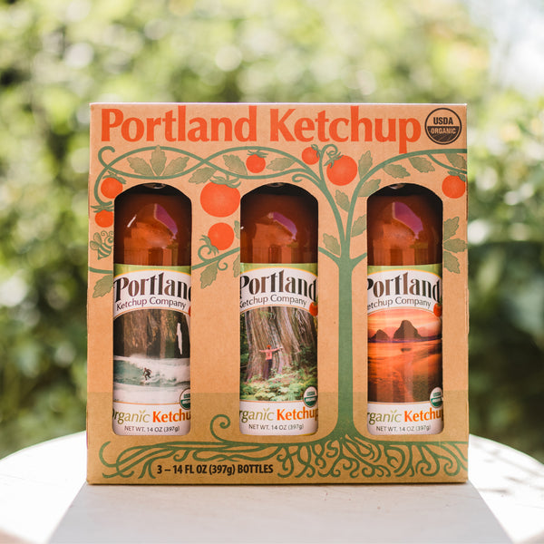 Portland Organic Ketchup 3-Bottle Gift Pack sitting on a table outside, no GMOs, Gluten Free, Dairy Free 